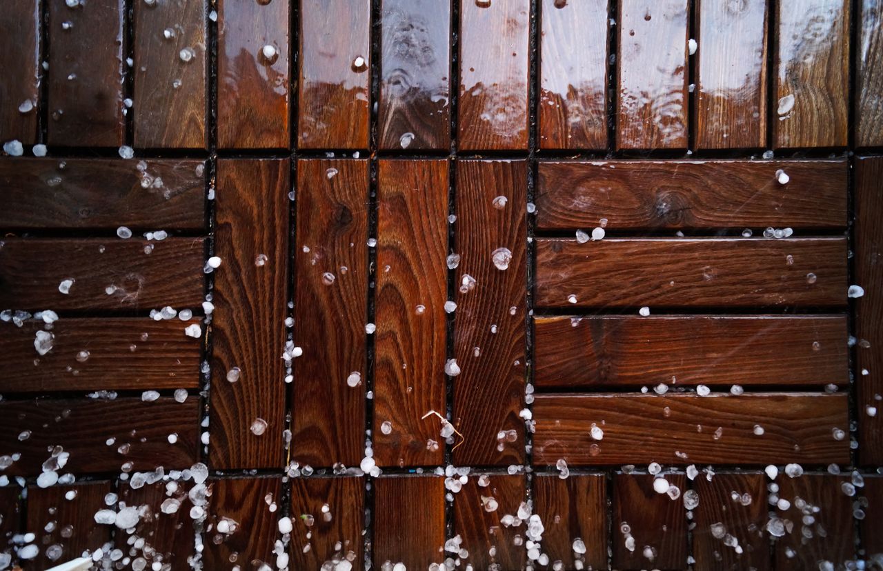 Crafting Captivating Headlines: Your awesome post title goes here Close-up of a wet wooden deck sprinkled with sleet and snowflakes, showcasing natural texture.